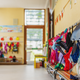 Empty hallway in the school, backpacks, and bags on hooks, bright recreation room